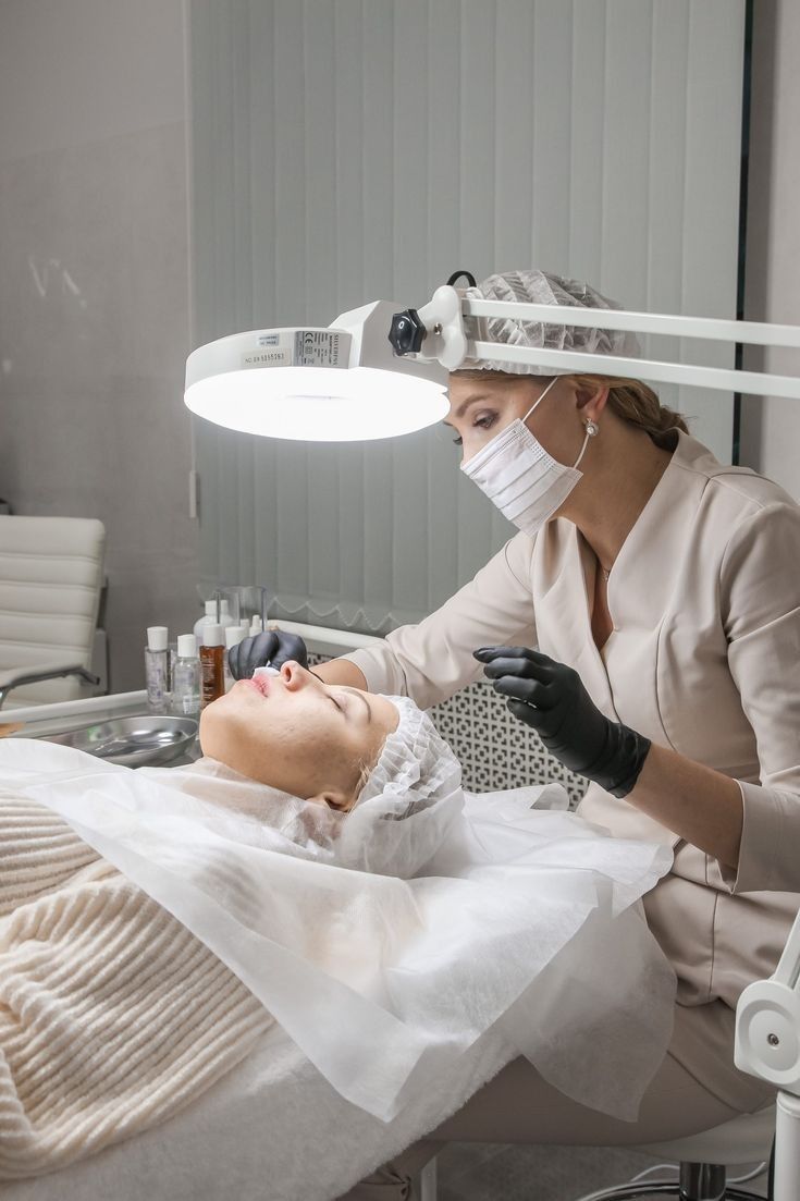 EliteMD practitioner assessing a client's skin under clinical magnification